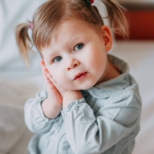 niña se lleva manos a la oreja por otitis