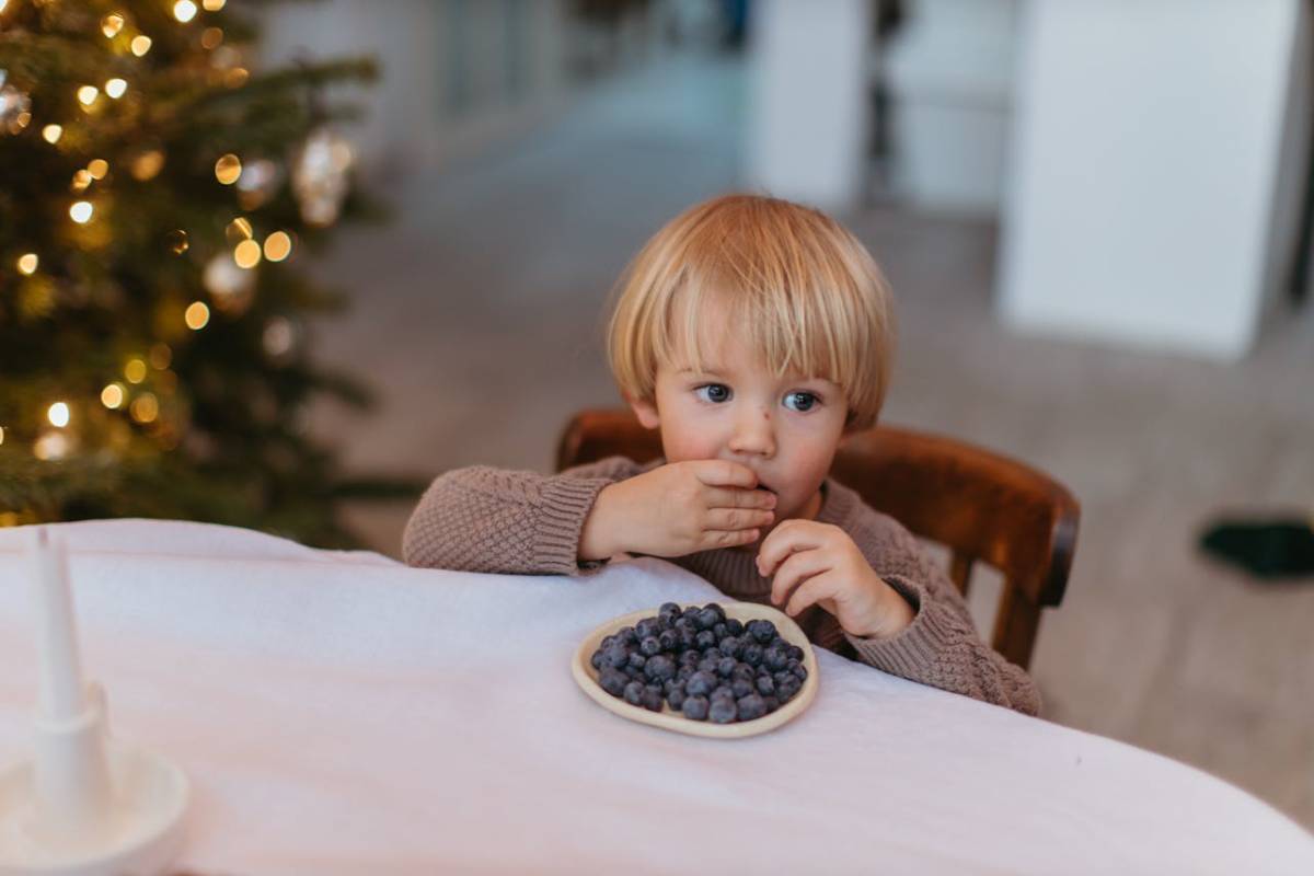 niño come frutos del bosque