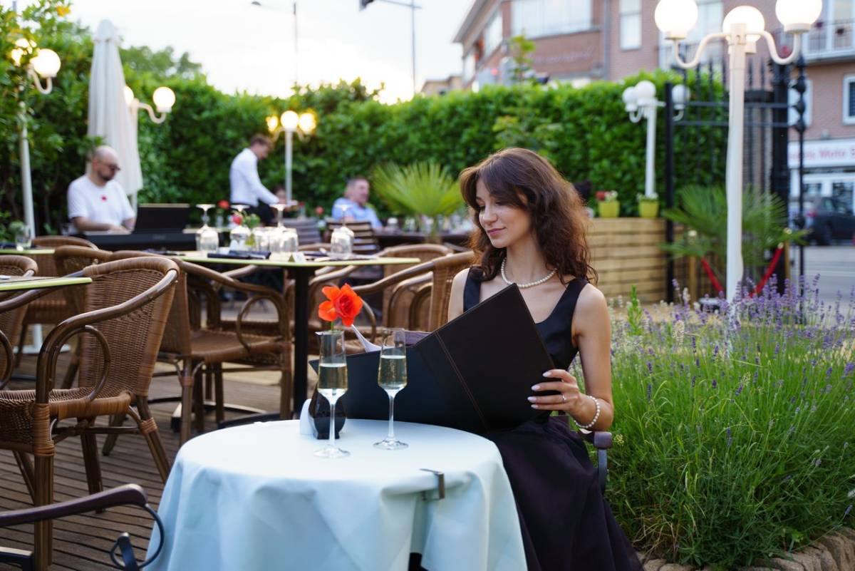 mujer mira la carta en una terraza