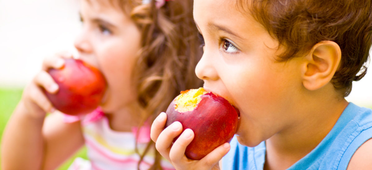 Happy children eating apple