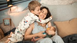 Niño abrazando a madre con niño en brazos