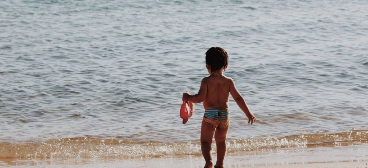 niño en la orilla playa