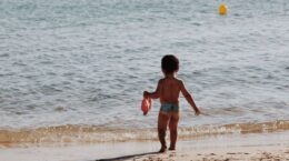 niño en la orilla playa