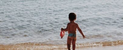 niño en la orilla playa