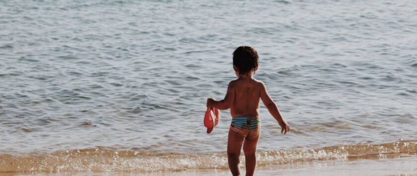niño en la orilla playa