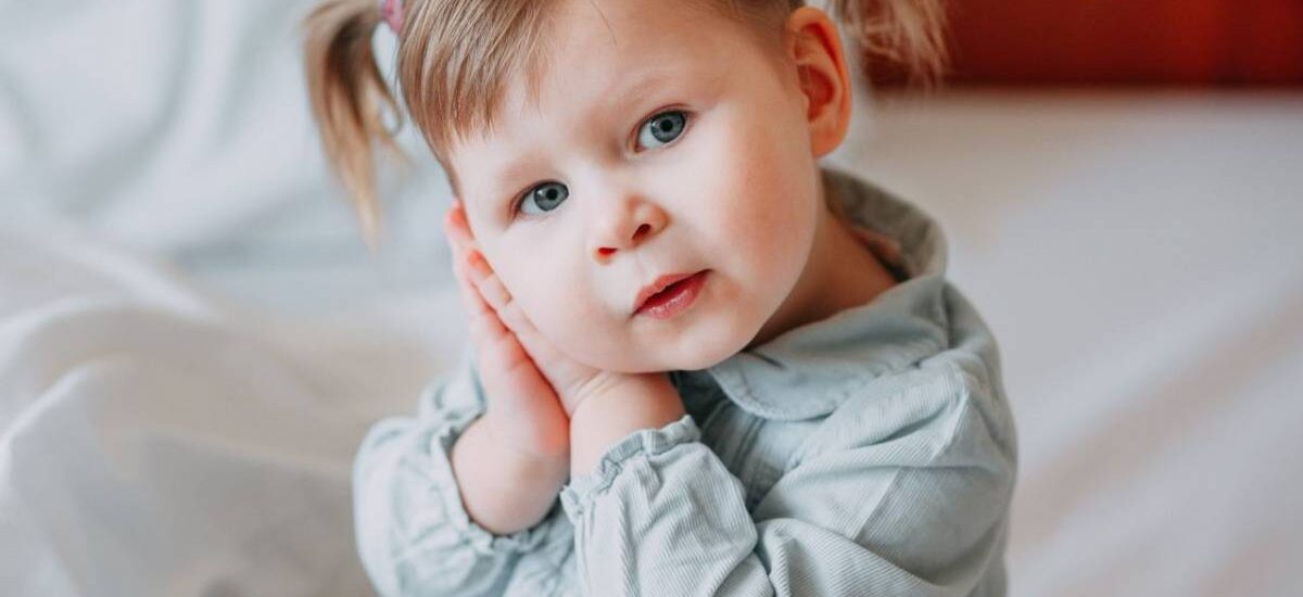otitis-dolor-oidos niña se lleva manos a la oreja por otitis