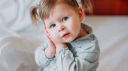 niña se lleva manos a la oreja por otitis