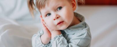 niña se lleva manos a la oreja por otitis