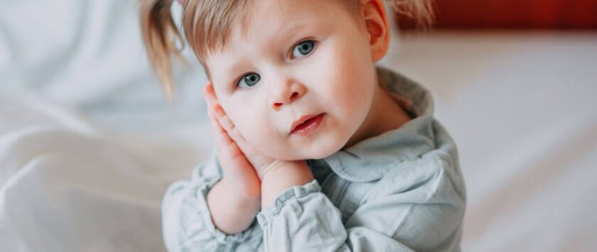 niña se lleva manos a la oreja por otitis