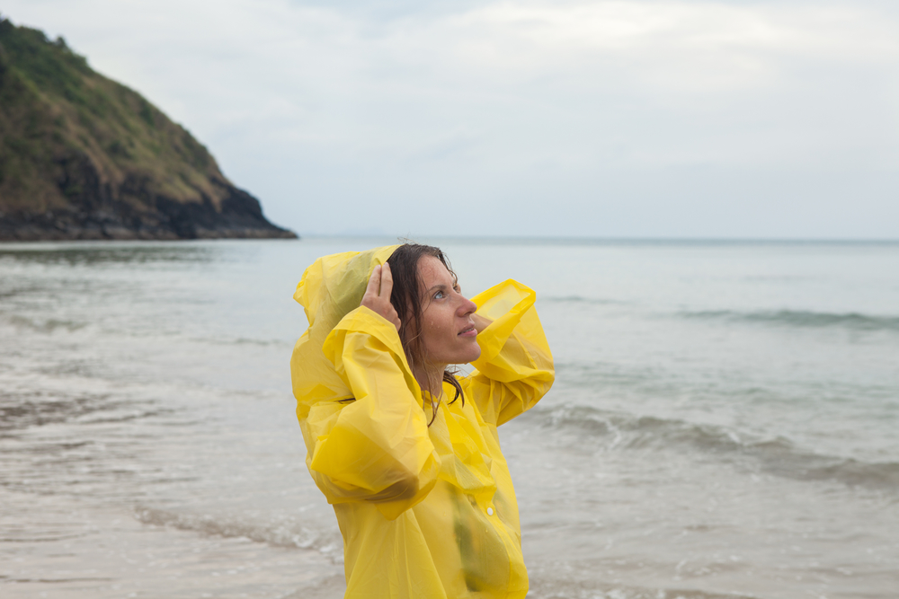Mujer playa lluvia chubasquero